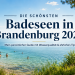 Klarer Badesee in Brandenburg mit bewaldetem Ufer, Badegästen, Sandstrand und Fahrrad am See