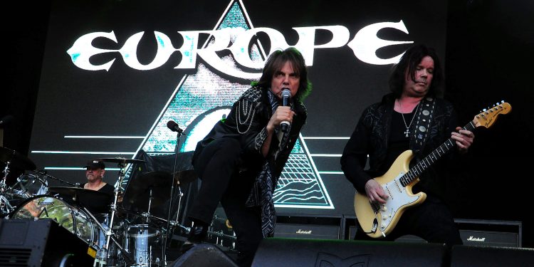 Europe live auf der Bühne bei einem Rockkonzert mit Sänger, Gitarrist und beleuchtetem Bandlogo