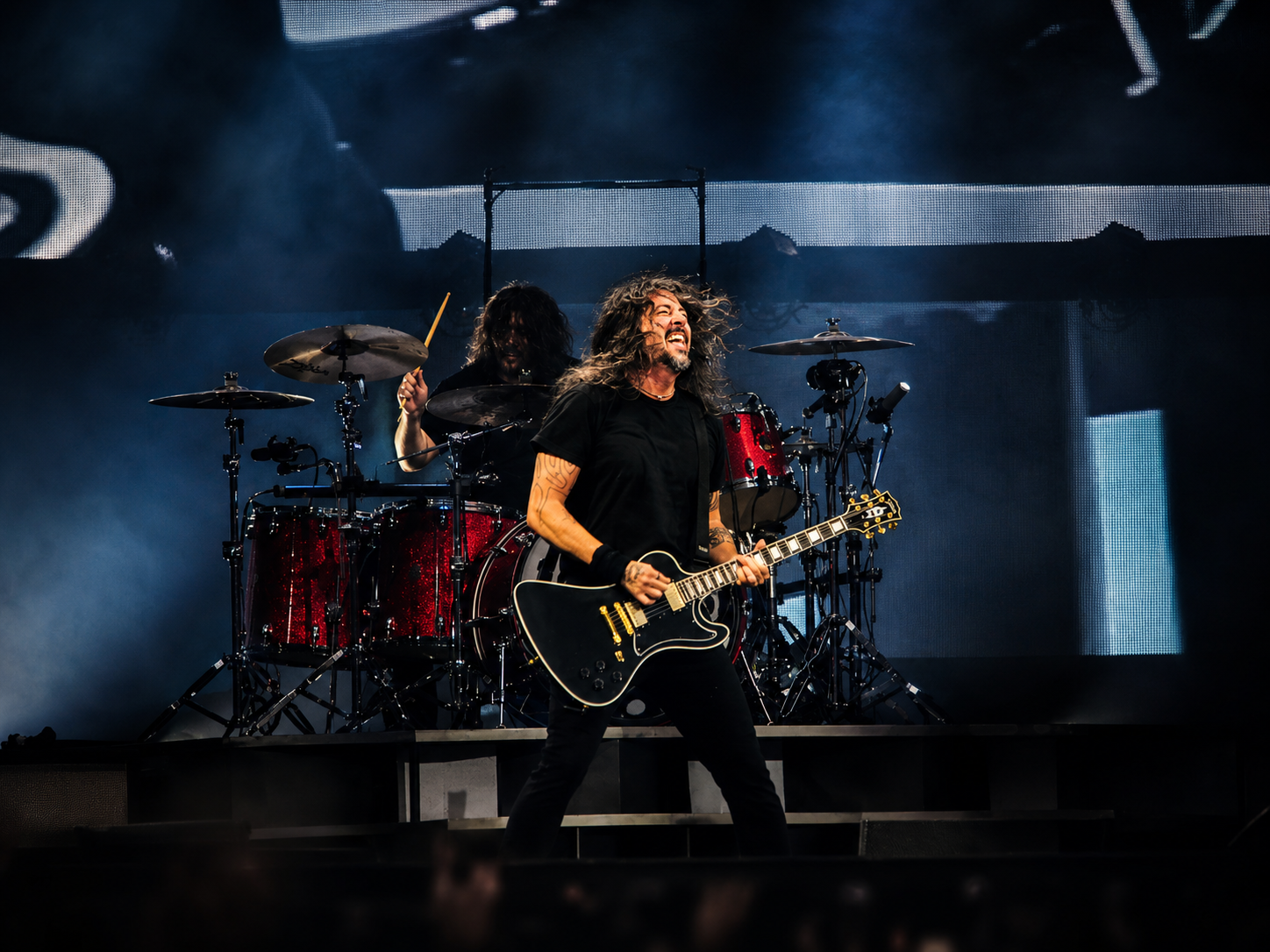 Sänger und Gitarrist der Foo Fighters spielt vor dem roten Schlagzeug auf der Bühne des Olympiastadions Berlin.