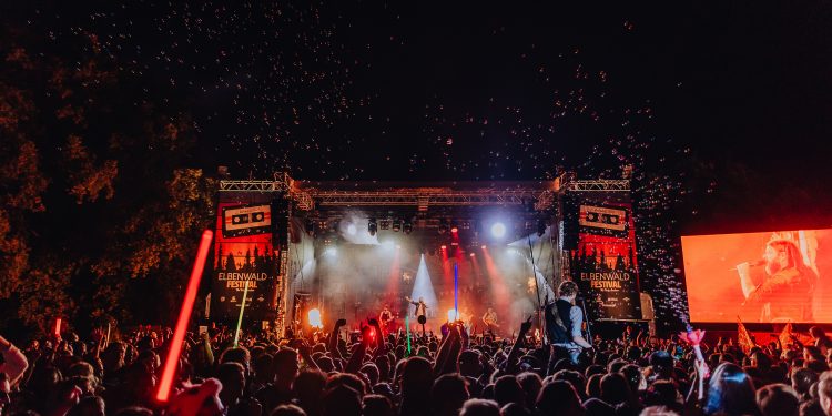 Versengold spielt beim Elbenwald Festival im Spreeauenpark Cottbus vor einer großen Menge im nächtlichen Bühnenlicht