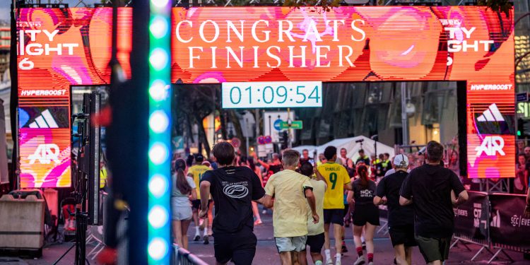 Läufer erreichen bei der adidas Runners City Night Berlin 2026 das beleuchtete Ziel auf dem Kurfürstendamm