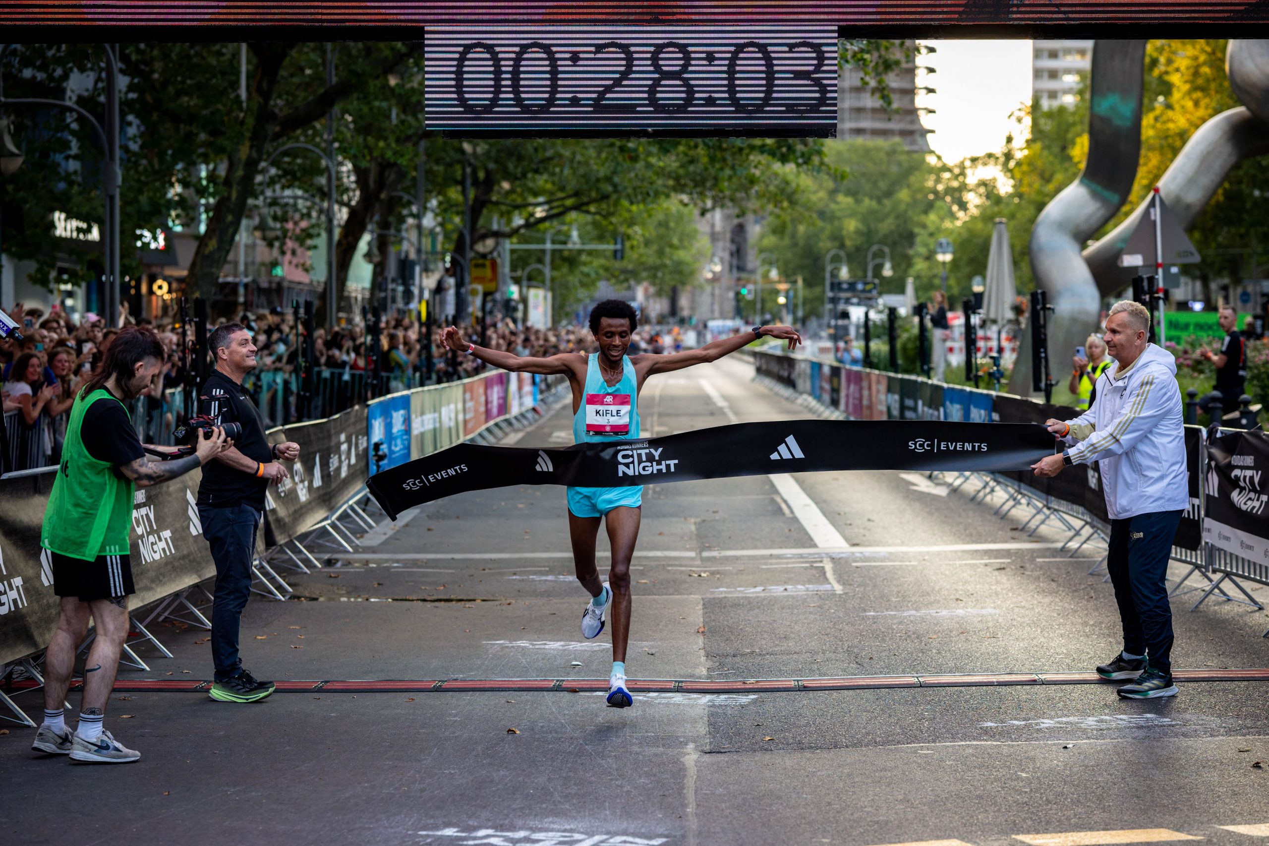 Läufer erreichen bei der adidas Runners City Night Berlin 2026 das beleuchtete Ziel auf dem Kurfürstendamm
