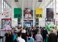 Besucher in einer Messehalle der IFA Berlin mit großen IFA-Bannern und Technikständen