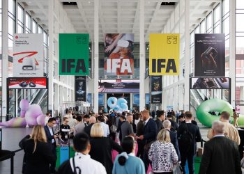 Besucher in einer Messehalle der IFA Berlin mit großen IFA-Bannern und Technikständen