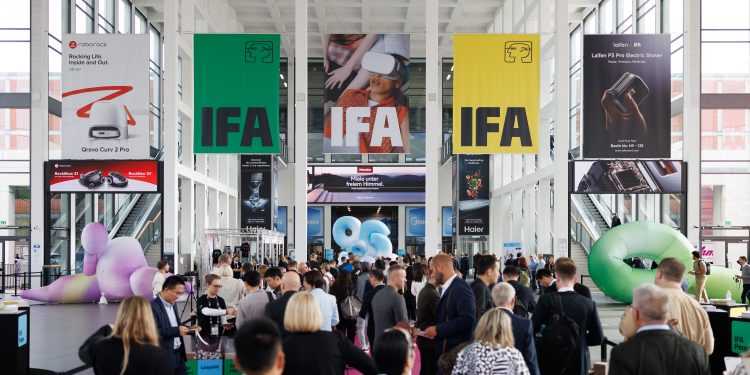 Besucher in einer Messehalle der IFA Berlin mit großen IFA-Bannern und Technikständen