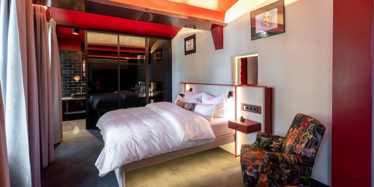 Zellenzimmer im THE KNAST Hotel Berlin-Lichterfelde mit Doppelbett und weinrotem Interior