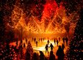 DARK MATTER WINTERLIGHTS 2026 in Berlin: Besucher laufen Schlittschuh auf einer leuchtenden Eisbahn unter Tausenden orange-roten Lichtern und hängenden Tannenbäumen.