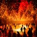 DARK MATTER WINTERLIGHTS 2026 in Berlin: Besucher laufen Schlittschuh auf einer leuchtenden Eisbahn unter Tausenden orange-roten Lichtern und hängenden Tannenbäumen.