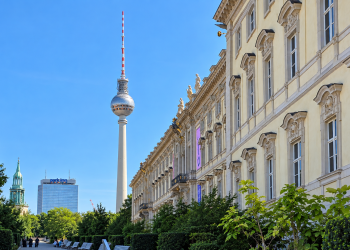 Berliner Fernsehturm neben historischer Fassade und Grünanlage in Berlin-Mitte