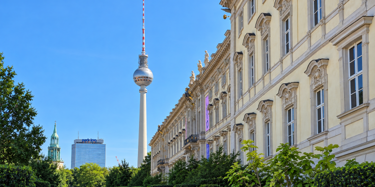 Berliner Fernsehturm neben historischer Fassade und Grünanlage in Berlin-Mitte