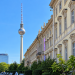 Berliner Fernsehturm neben historischer Fassade und Grünanlage in Berlin-Mitte