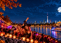 Halloween-Party in Berlin mit verkleideten Gästen, Kürbissen und nächtlicher Stadtkulisse an der Spree