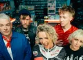 Jennifer Rostock auf einem aktuellen Bandfoto von 2026: Die fünf Musiker stehen gemeinsam in einem Kiosk. Am 8. Mai 2027 spielt die Band im Velodrom Berlin.