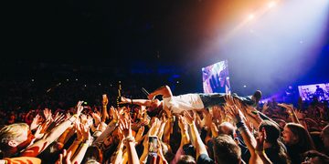 Nico Santos beim Crowdsurfing während eines Konzerts vor jubelndem Publikum