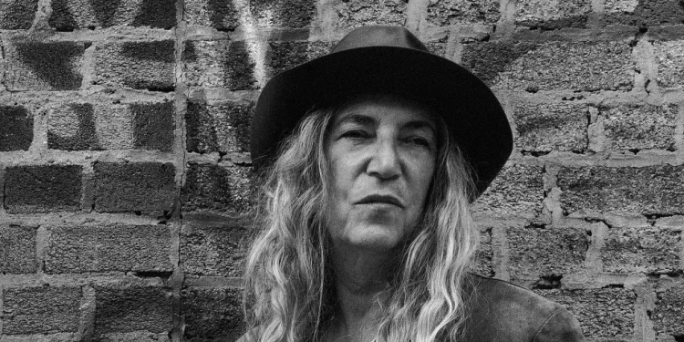 Patti Smith mit Hut und langen Haaren vor einer Backsteinwand – Porträt der Rockmusikerin, die 2027 in der Zitadelle Spandau auftritt