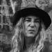 Patti Smith mit Hut und langen Haaren vor einer Backsteinwand – Porträt der Rockmusikerin, die 2027 in der Zitadelle Spandau auftritt