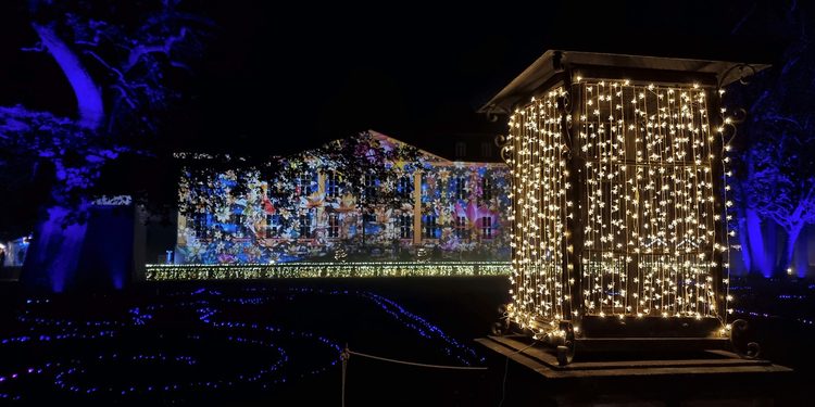Beleuchtete Laterne und farbenprächtige Lichtprojektionen am Schloss Friedrichsfelde bei Weihnachten im Tierpark Berlin